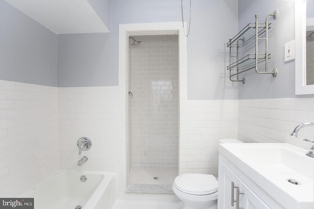 full bathroom featuring toilet, vanity, tile walls, and tile patterned flooring