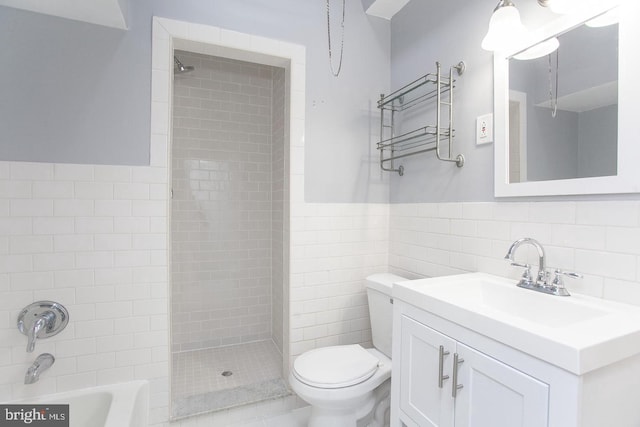 bathroom featuring vanity, toilet, and tile walls