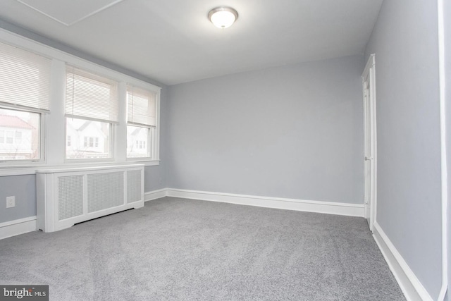 carpeted empty room with radiator heating unit