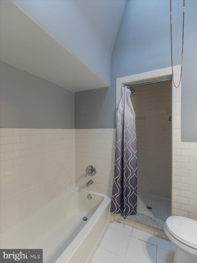 bathroom featuring toilet, tile walls, tile patterned floors, and separate shower and tub