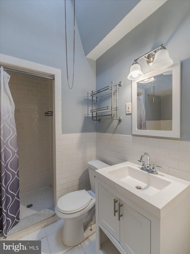 bathroom with tile walls, vanity, tile patterned flooring, curtained shower, and toilet