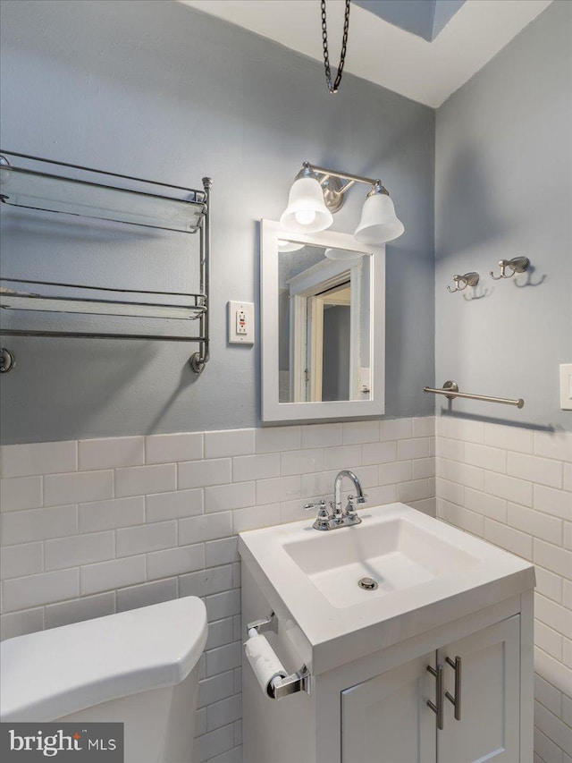 bathroom with toilet, vanity, tile walls, and radiator