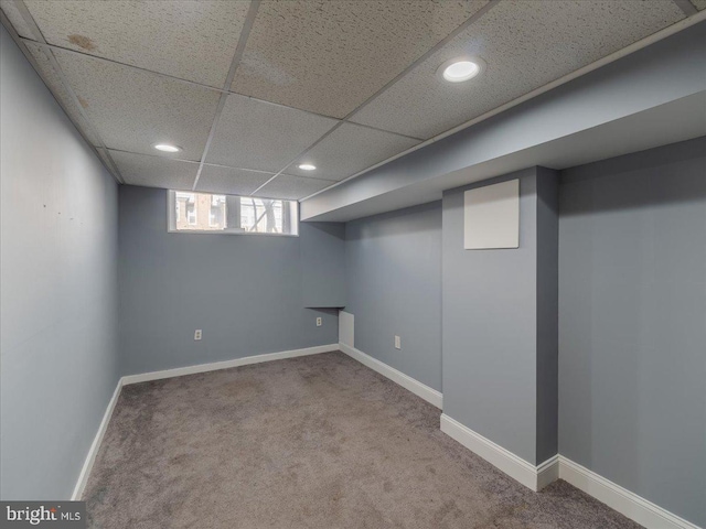 basement featuring carpet flooring and a drop ceiling