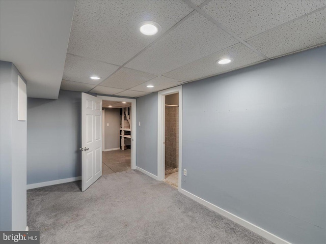 basement featuring light colored carpet and a drop ceiling