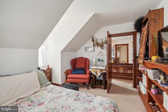 bedroom featuring light colored carpet and vaulted ceiling