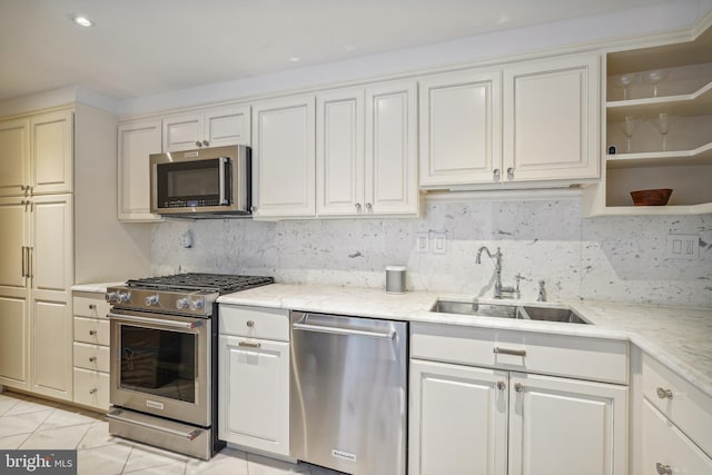 kitchen featuring appliances with stainless steel finishes, sink, decorative backsplash, and light tile patterned floors