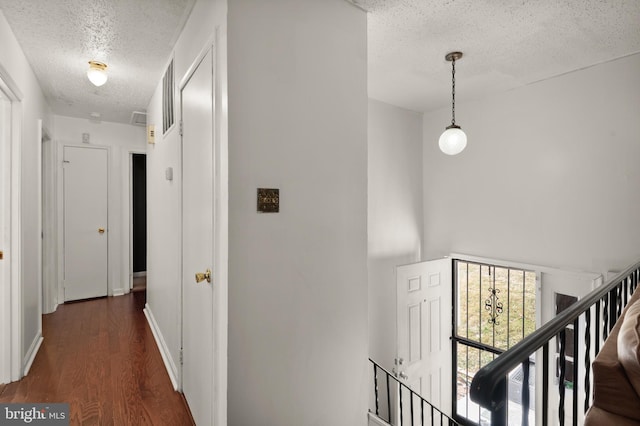 hallway featuring dark hardwood / wood-style flooring and a textured ceiling