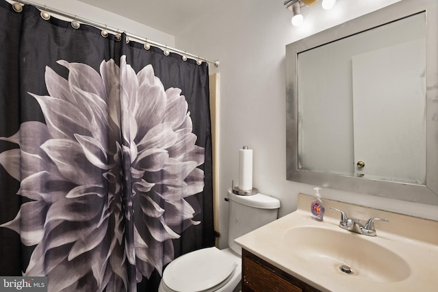 bathroom featuring walk in shower, vanity, and toilet