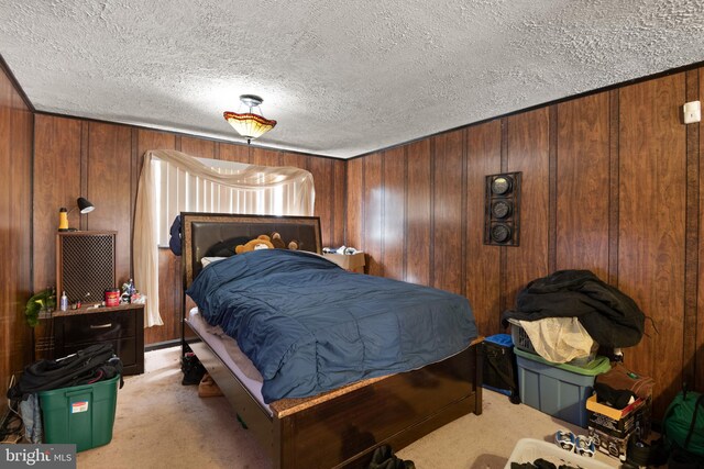 carpeted bedroom featuring a textured ceiling and wooden walls