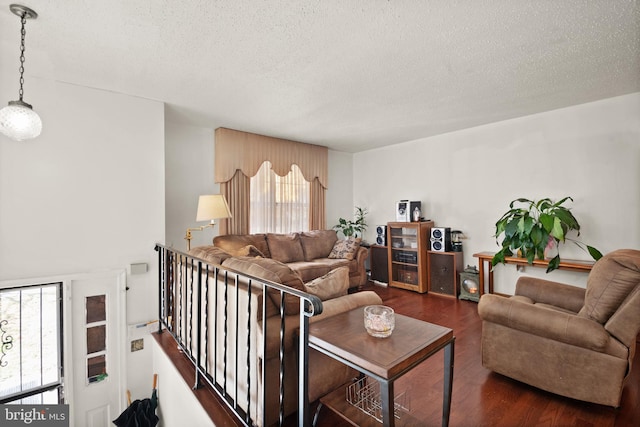 living room with plenty of natural light, a textured ceiling, and dark hardwood / wood-style flooring