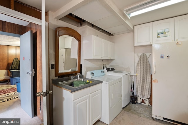 washroom with wooden walls, cabinets, sink, and washer and dryer