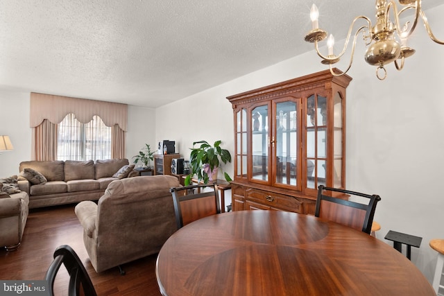 dining room featuring a textured ceiling, an inviting chandelier, and dark hardwood / wood-style flooring