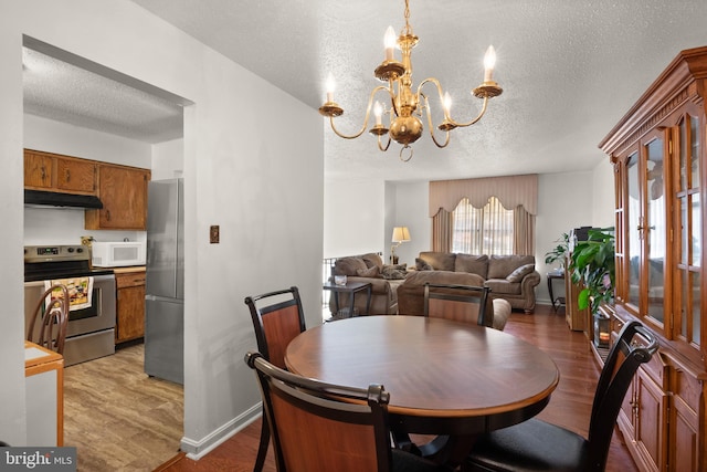 dining area with a chandelier, a textured ceiling, and hardwood / wood-style flooring