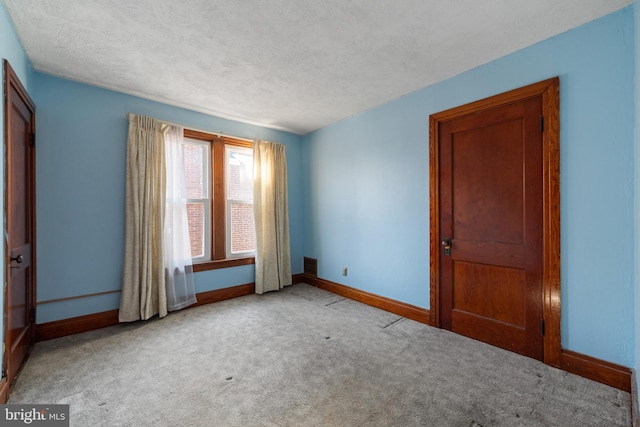 unfurnished room with light carpet and a textured ceiling