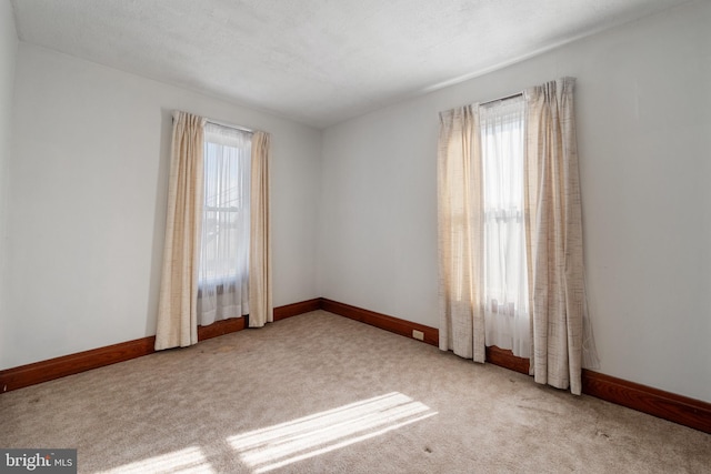 carpeted spare room featuring a wealth of natural light