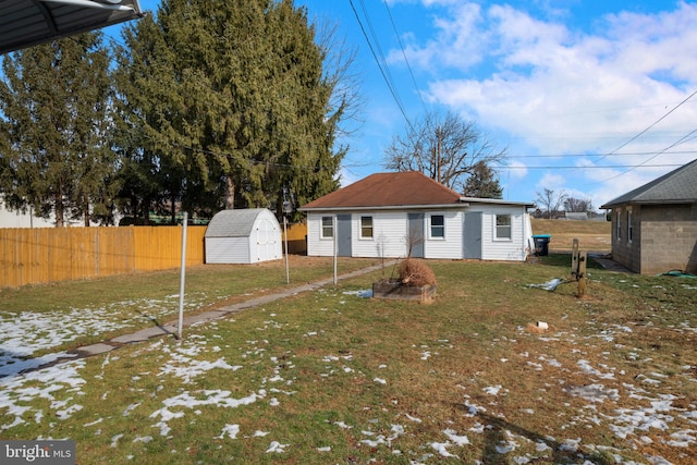 back of property featuring a yard and a storage unit