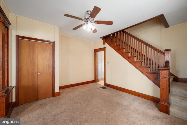 unfurnished living room featuring light carpet and ceiling fan