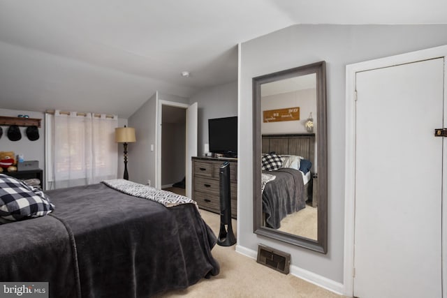 bedroom featuring light colored carpet and lofted ceiling