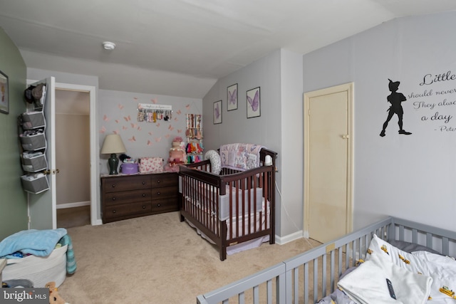 carpeted bedroom with lofted ceiling and a nursery area