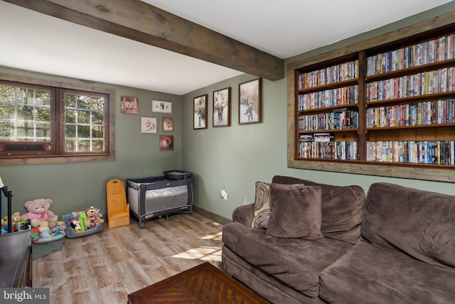 living room with light hardwood / wood-style floors and beamed ceiling