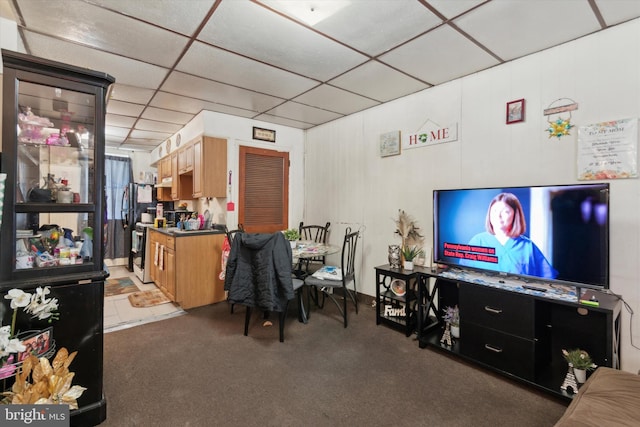 carpeted living room with a drop ceiling