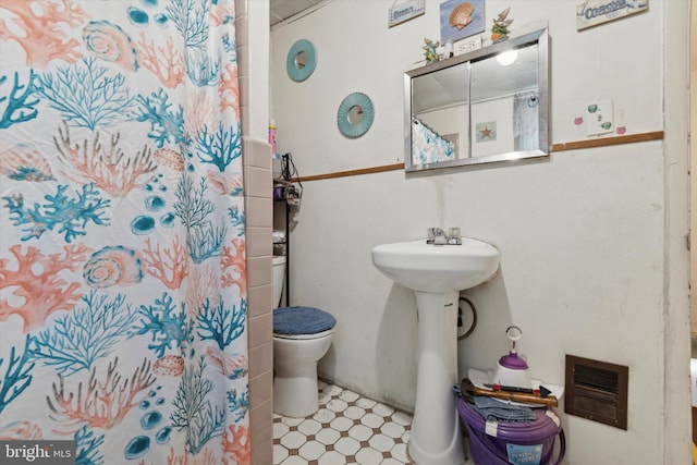 bathroom with a shower with curtain and toilet