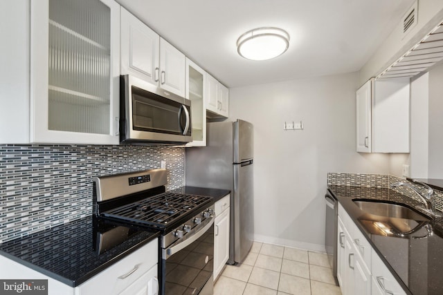 kitchen featuring stainless steel appliances, light tile patterned flooring, sink, backsplash, and white cabinets