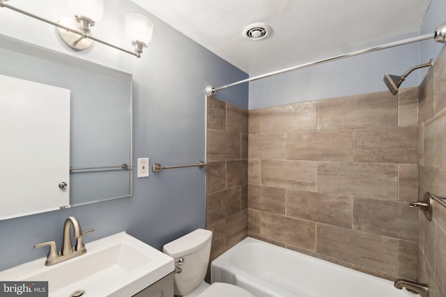 full bathroom with vanity, toilet, and tiled shower / bath combo