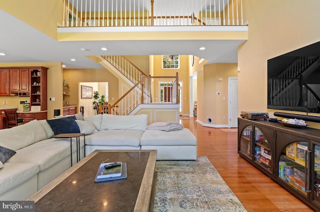 living room featuring a high ceiling and light hardwood / wood-style flooring