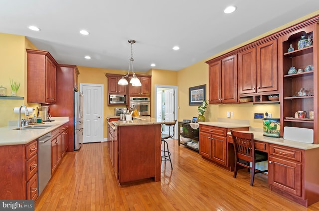 kitchen featuring stainless steel appliances, sink, a breakfast bar, light wood-type flooring, and pendant lighting