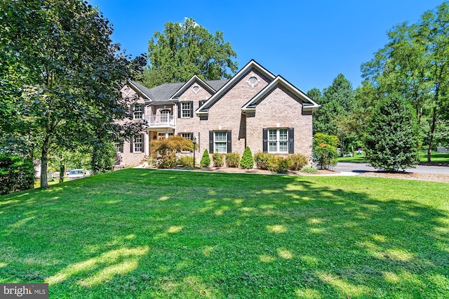 view of front of property with a balcony and a front yard