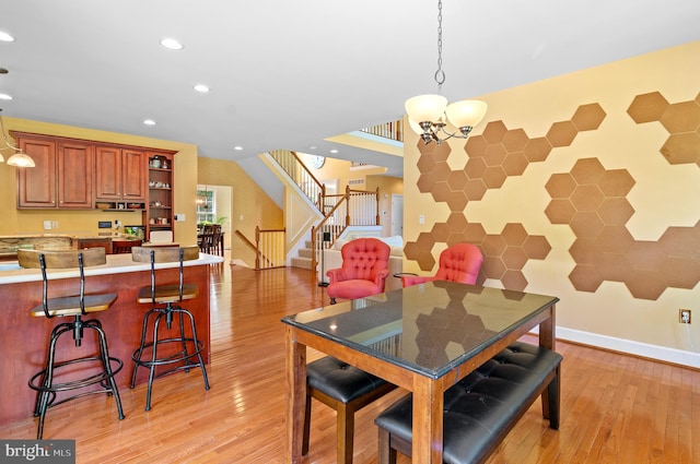 dining room with light hardwood / wood-style floors and a chandelier