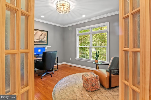 home office featuring wood-type flooring, a notable chandelier, and ornamental molding