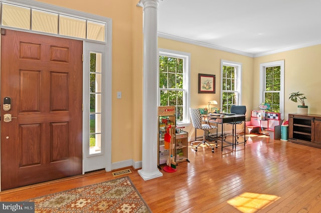 entryway featuring light hardwood / wood-style floors, plenty of natural light, ornate columns, and crown molding