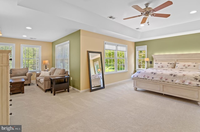 bedroom featuring multiple windows, light colored carpet, and ceiling fan