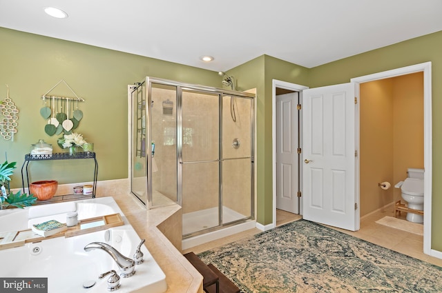 bathroom featuring tile patterned floors, toilet, and separate shower and tub