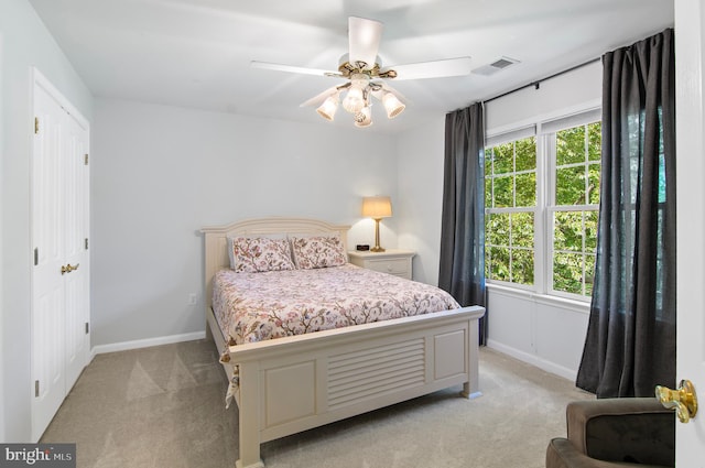 bedroom with multiple windows, light carpet, and ceiling fan