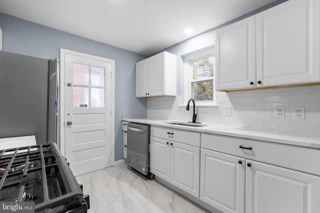 kitchen featuring light stone countertops, tasteful backsplash, stainless steel appliances, sink, and white cabinetry