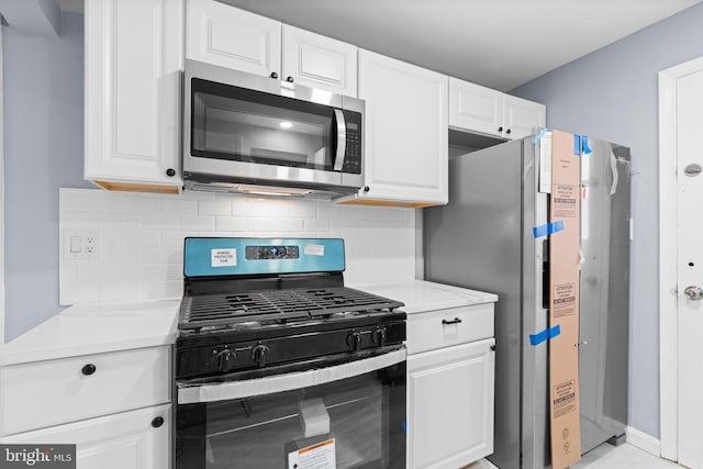 kitchen with decorative backsplash, stainless steel appliances, and white cabinetry