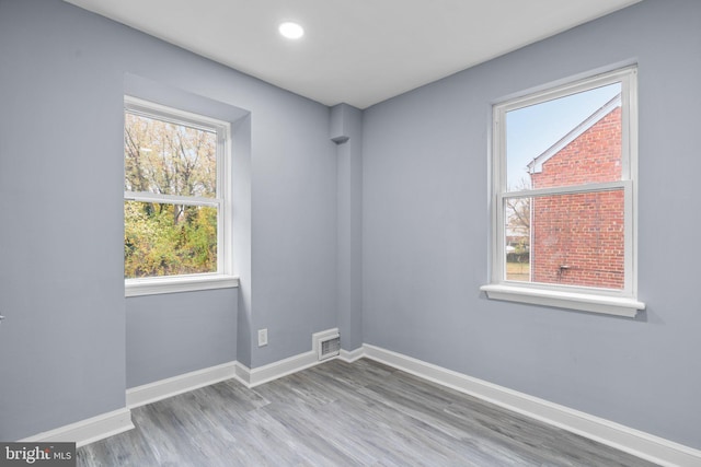 unfurnished room with hardwood / wood-style floors and a healthy amount of sunlight