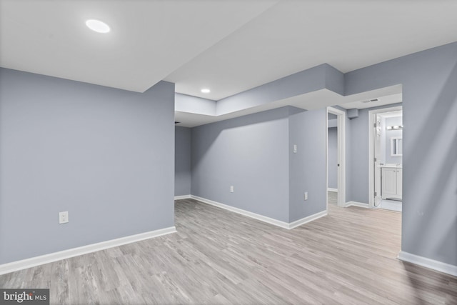 basement with light hardwood / wood-style flooring