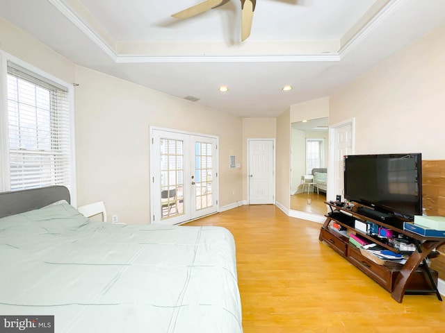 bedroom featuring light hardwood / wood-style floors, ceiling fan, multiple windows, and french doors