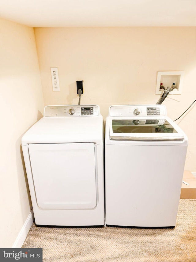 laundry room with light carpet and washer and clothes dryer