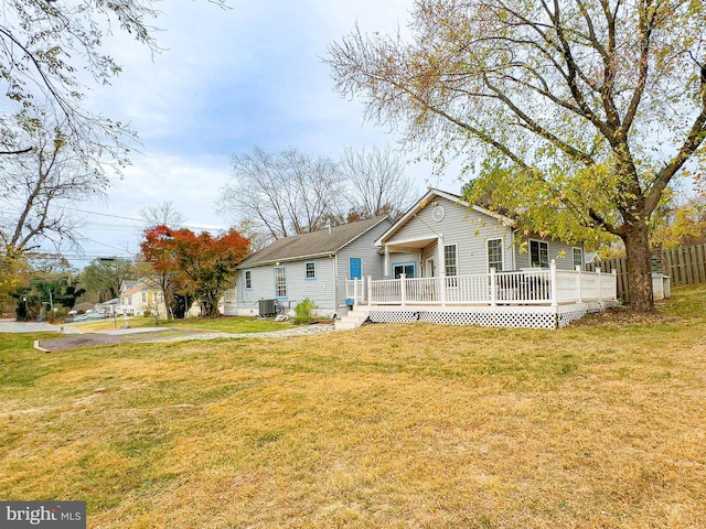 view of front facade featuring a front lawn, a wooden deck, and cooling unit