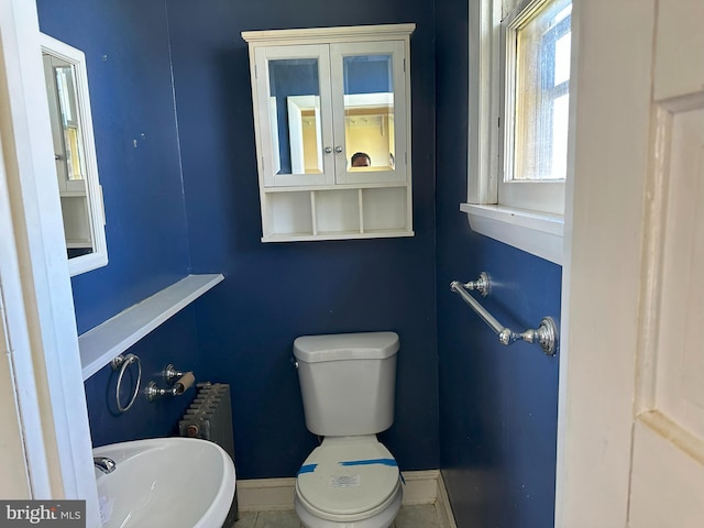 bathroom with radiator, tile patterned flooring, and toilet