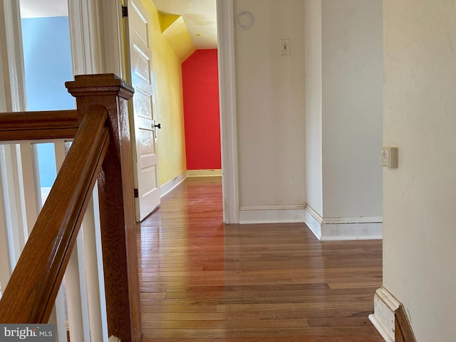 hall with vaulted ceiling and dark hardwood / wood-style flooring