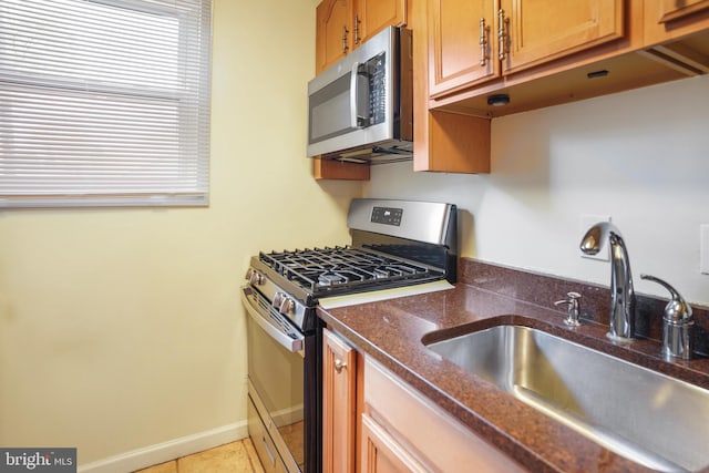 kitchen with sink, light tile patterned floors, and stainless steel appliances