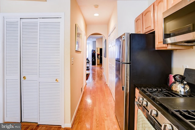 kitchen with light brown cabinets, light hardwood / wood-style floors, and stainless steel appliances