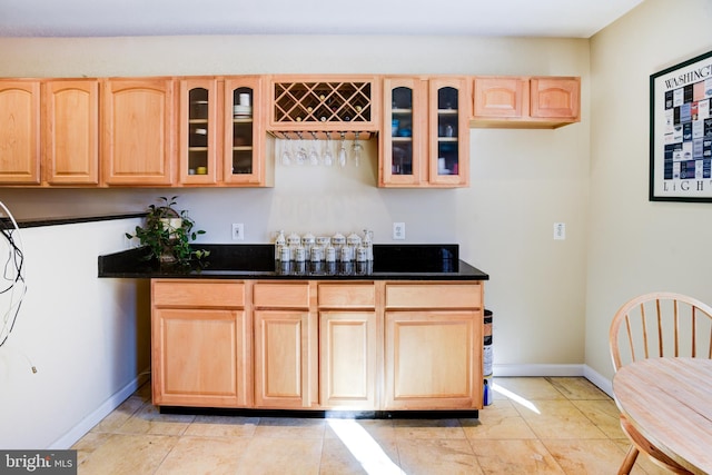 kitchen with dark stone counters and light brown cabinetry