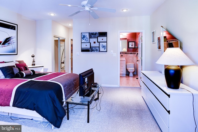 carpeted bedroom with ensuite bathroom, ceiling fan, and a closet